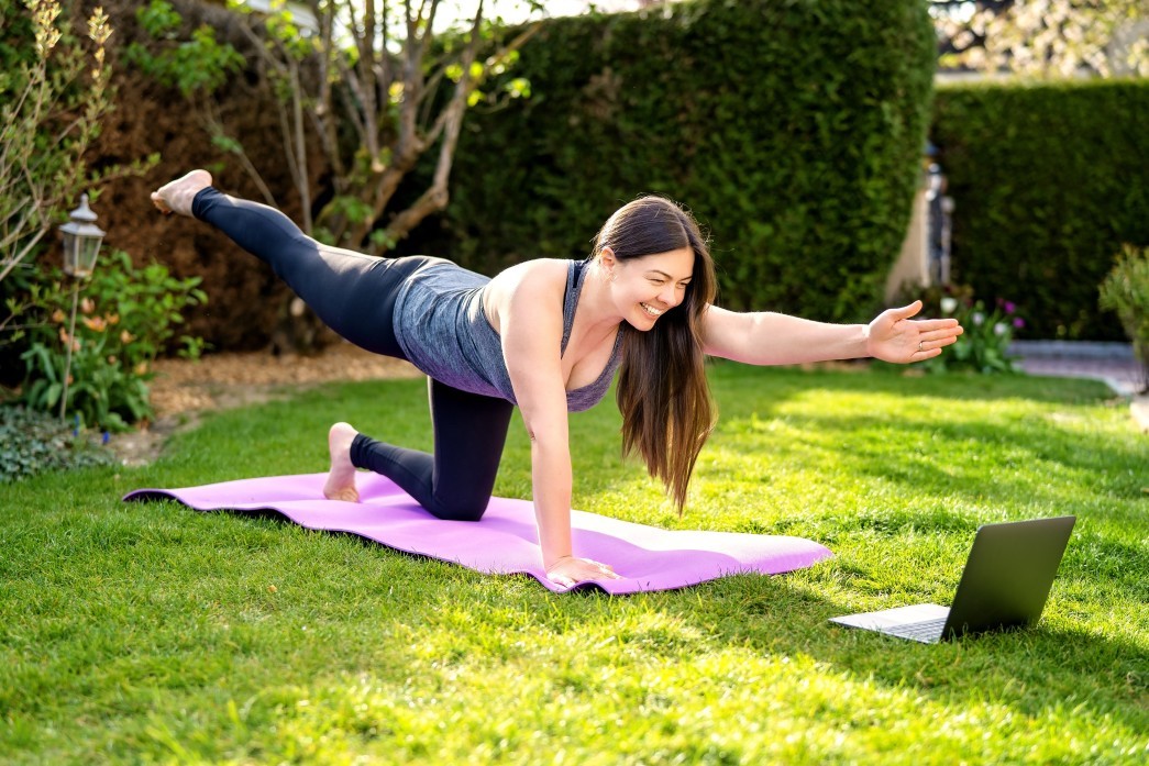 woman doing yoga outside in front of laptop with energy from b12 near you
